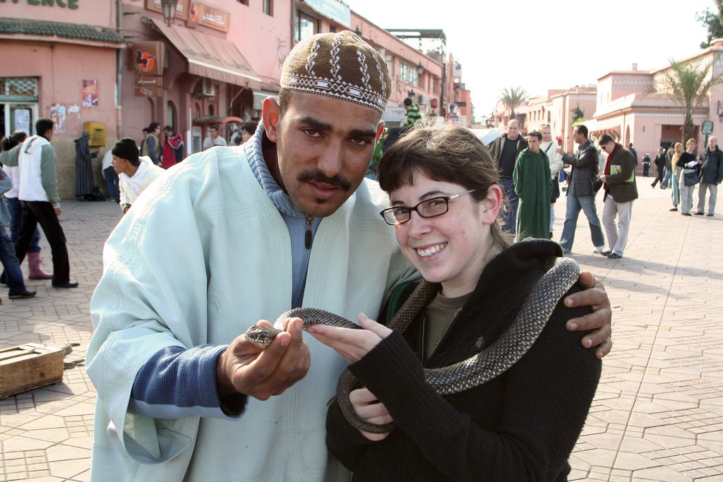 A tourist poses with a snake charmer