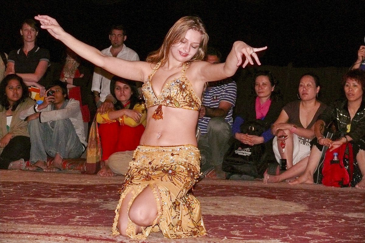 A (European) dancer belly dances in front of tourists in Dubai