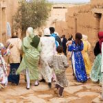 In the cobbled streets of Tissargate, a group of women in festive caftans join the bride from the back.