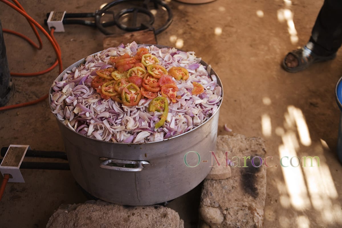 Une marmite remplie d'oignons, de tomates....