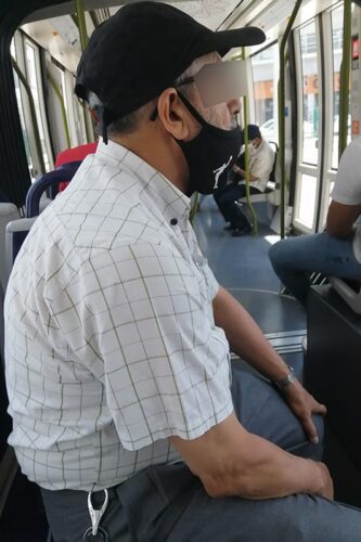 A Moroccan man wearing a mask over his nose and mouth on the tram