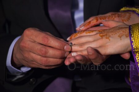 A man puts a wedding ring on his Moroccan wife's finger