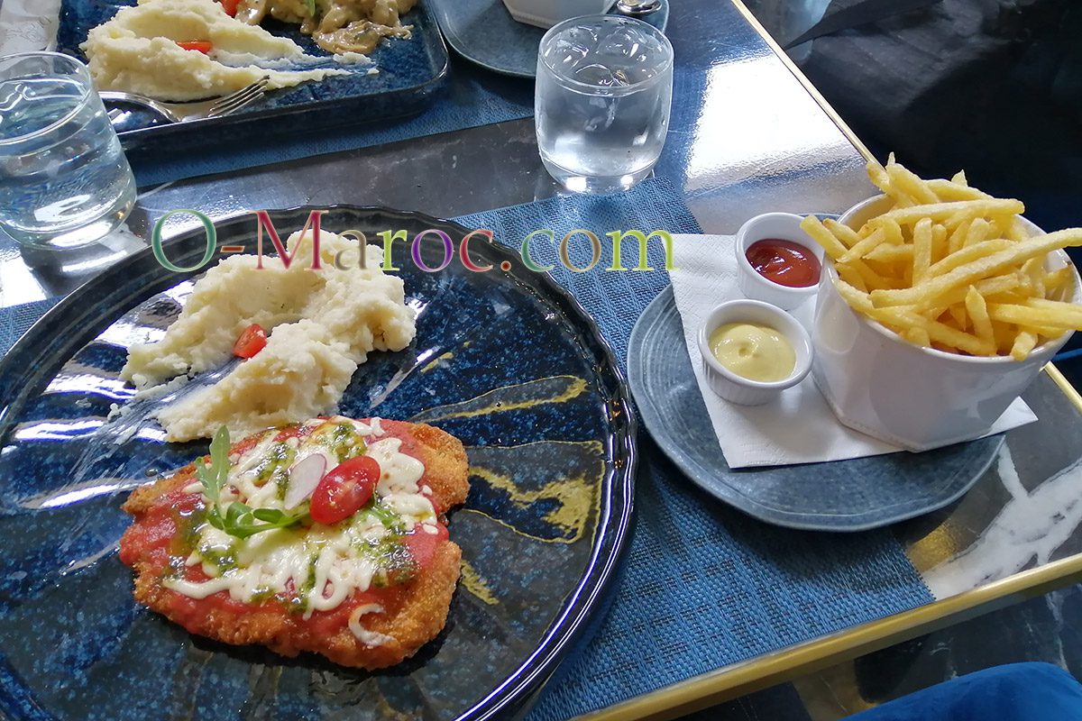 Breaded escalope, risotto and chips on a restaurant table