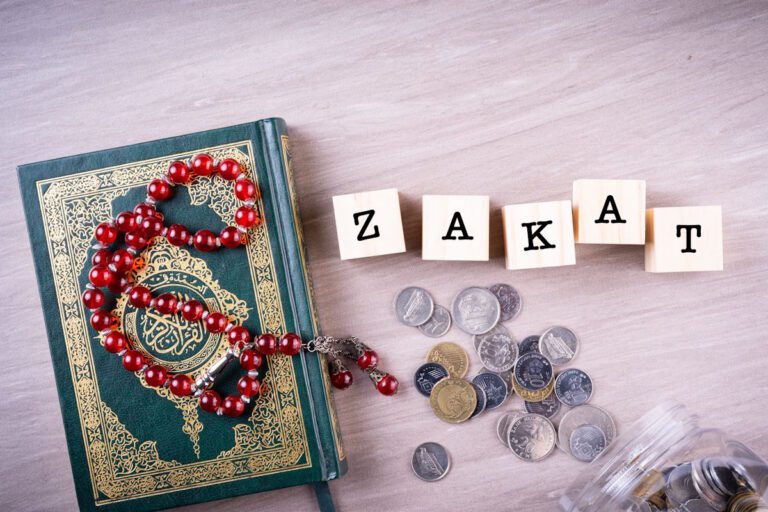 Zakat and Sadaqah, charity in Islam A Koran, a rosary, money and the word Zakat