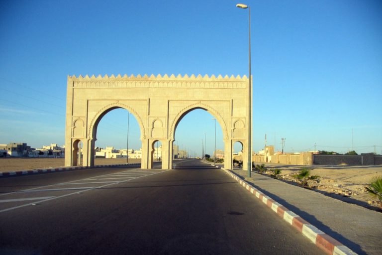 What is celebrated on 14 August in Morocco? A large gate on the road at the entrance to Dakhla
