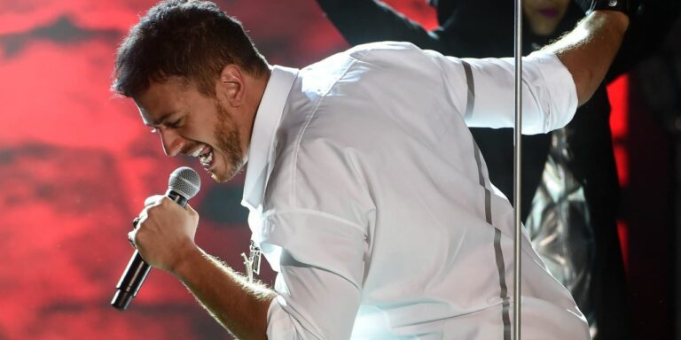 The pop singer seen in profile, holding a microphone