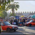 Many small red taxis in front of the souk walls in Agadir