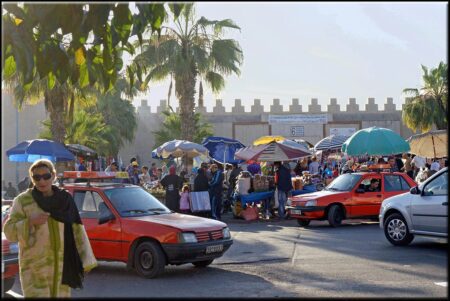 Many small red taxis in front of the souk walls in Agadir